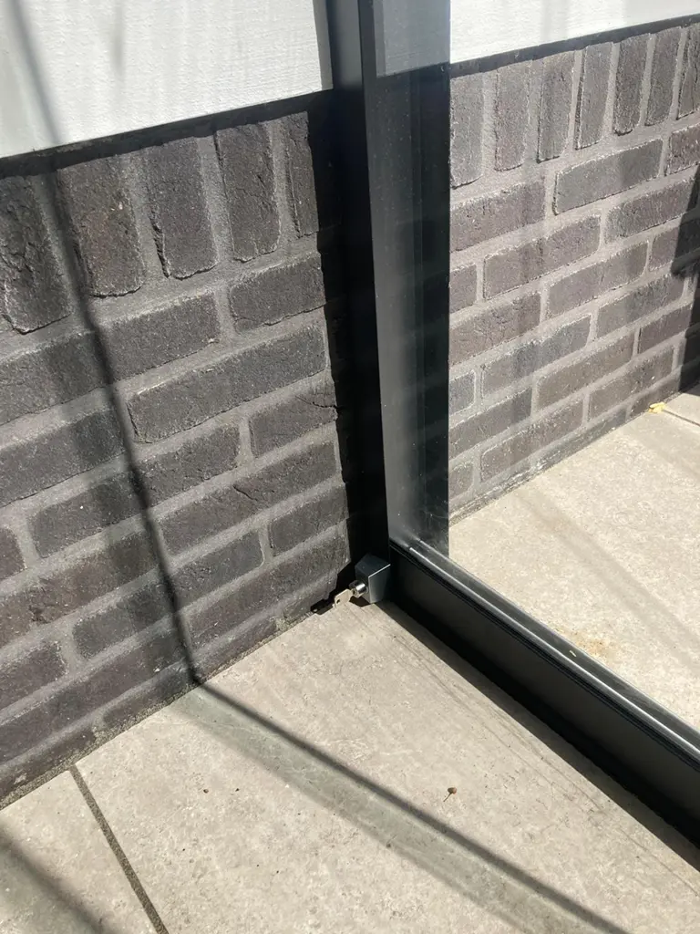 Detail van rails en frame van glazen schuifwand