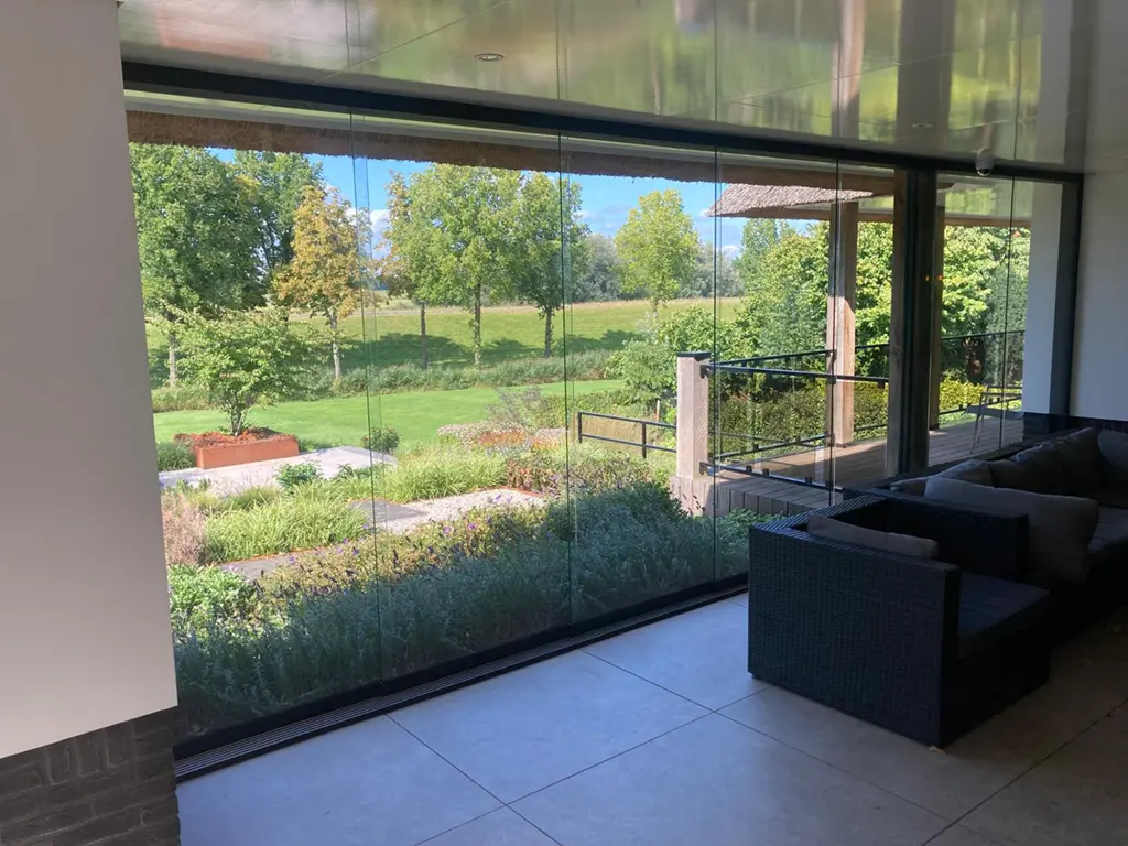 Moderne glazen schuifwand tussen woonkamer en tuin